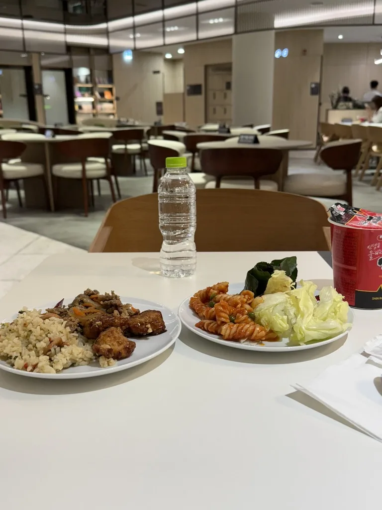 SkyHub Lounge late-night meal with fried rice, pasta, salad, and Shin Ramyun