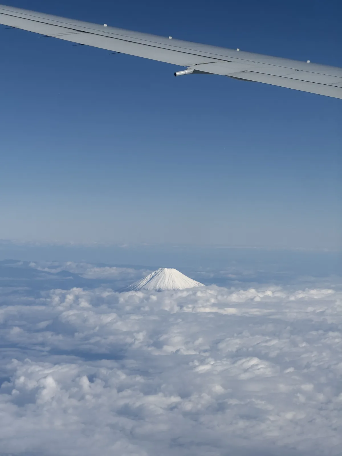 Snow-capped Mt. Fuji seen from left window seat during approach to Haneda Airport