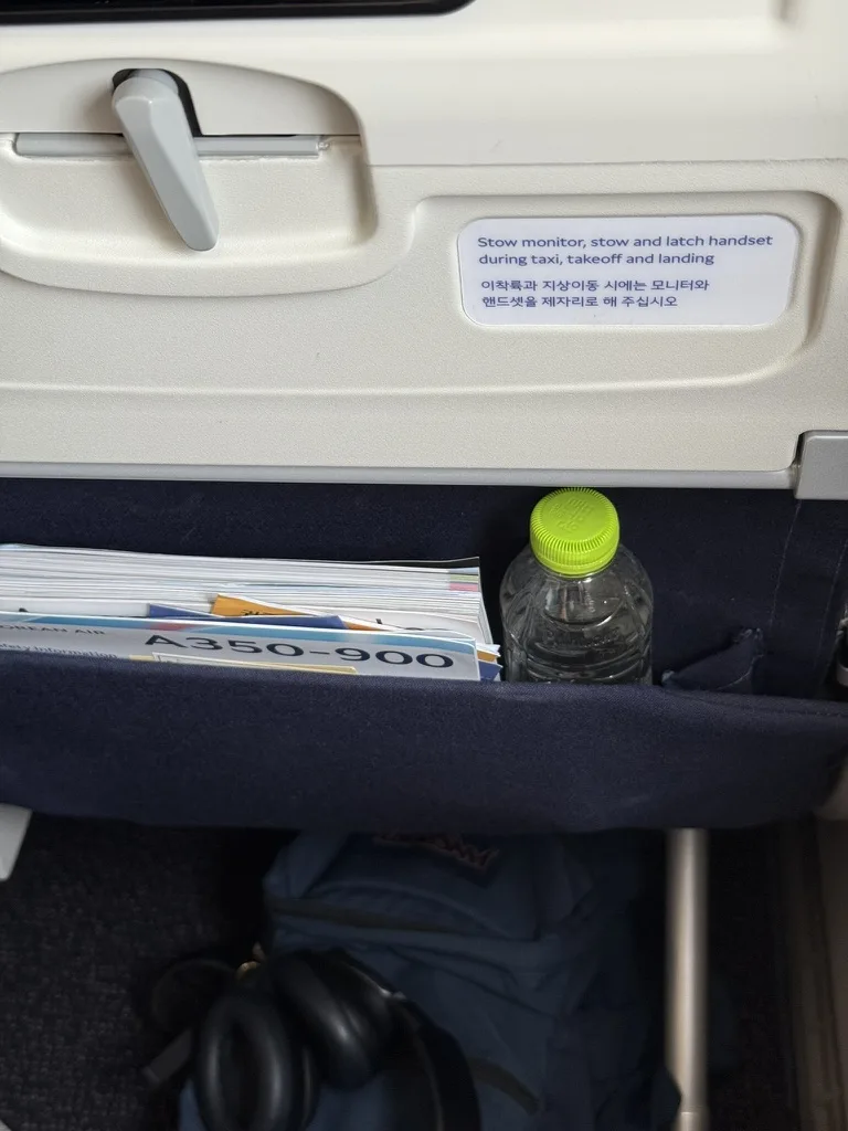 Economy seat pocket with safety card and water bottle