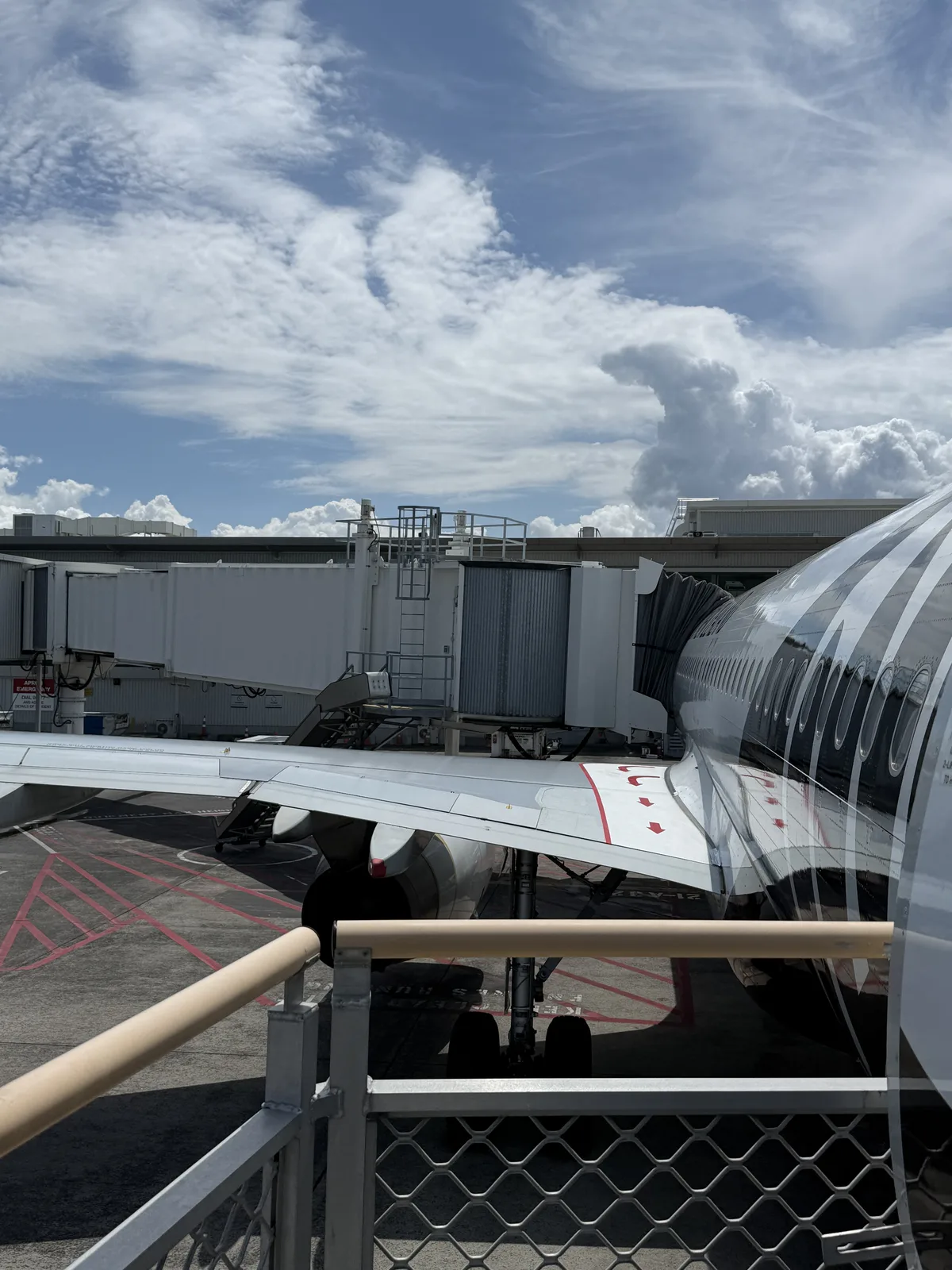 Air New Zealand A320 rear boarding door with jet bridge visible
