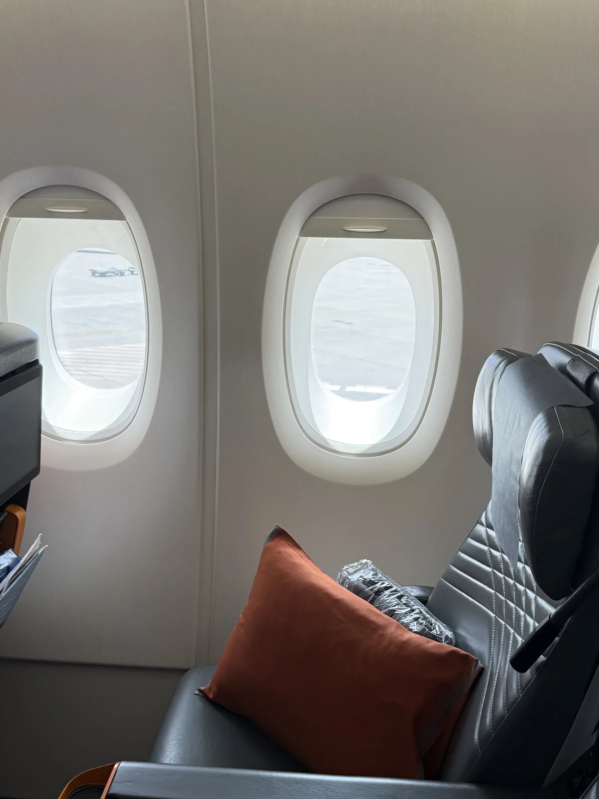 Singapore Airlines A380 economy class seat with pillow, blanket, and amenity pouch