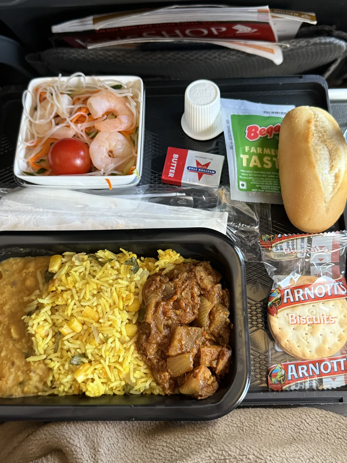 Singapore Airlines economy class meal tray with meat dish and ice cream