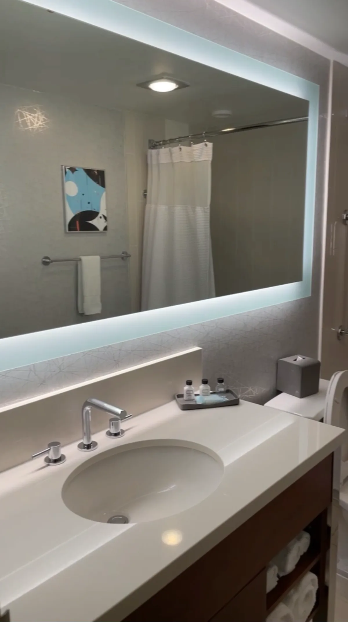 Crowne Plaza Seattle bathroom vanity with backlit mirror and single-use amenity bottles