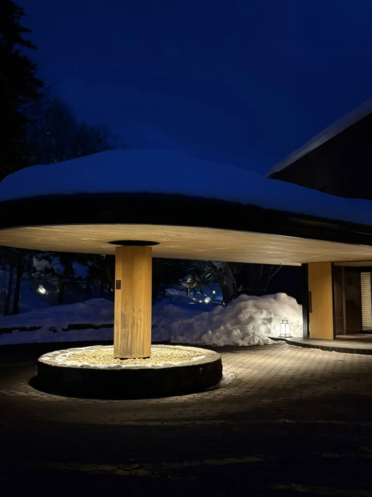 Kuriya Suizan ryokan exterior at night with snow-covered roof