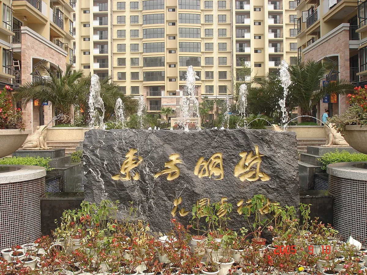 Entrance to a Chinese high-rise apartment complex with a fountain and carved stone