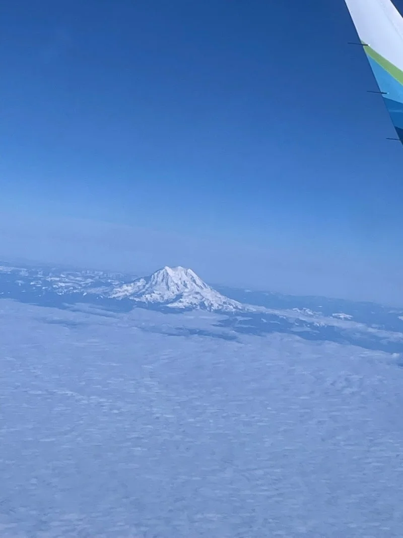 창밖 구름 위로 솟아오른 올림푸스 산(Mount Olympus)의 장관