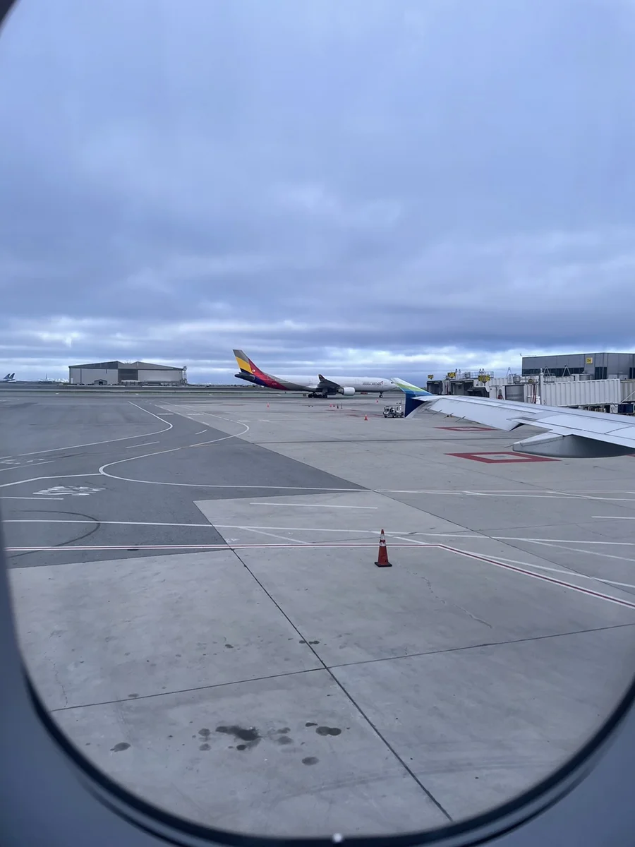 창밖으로 보이는 공항 계류장과 이동 중인 항공기 풍경